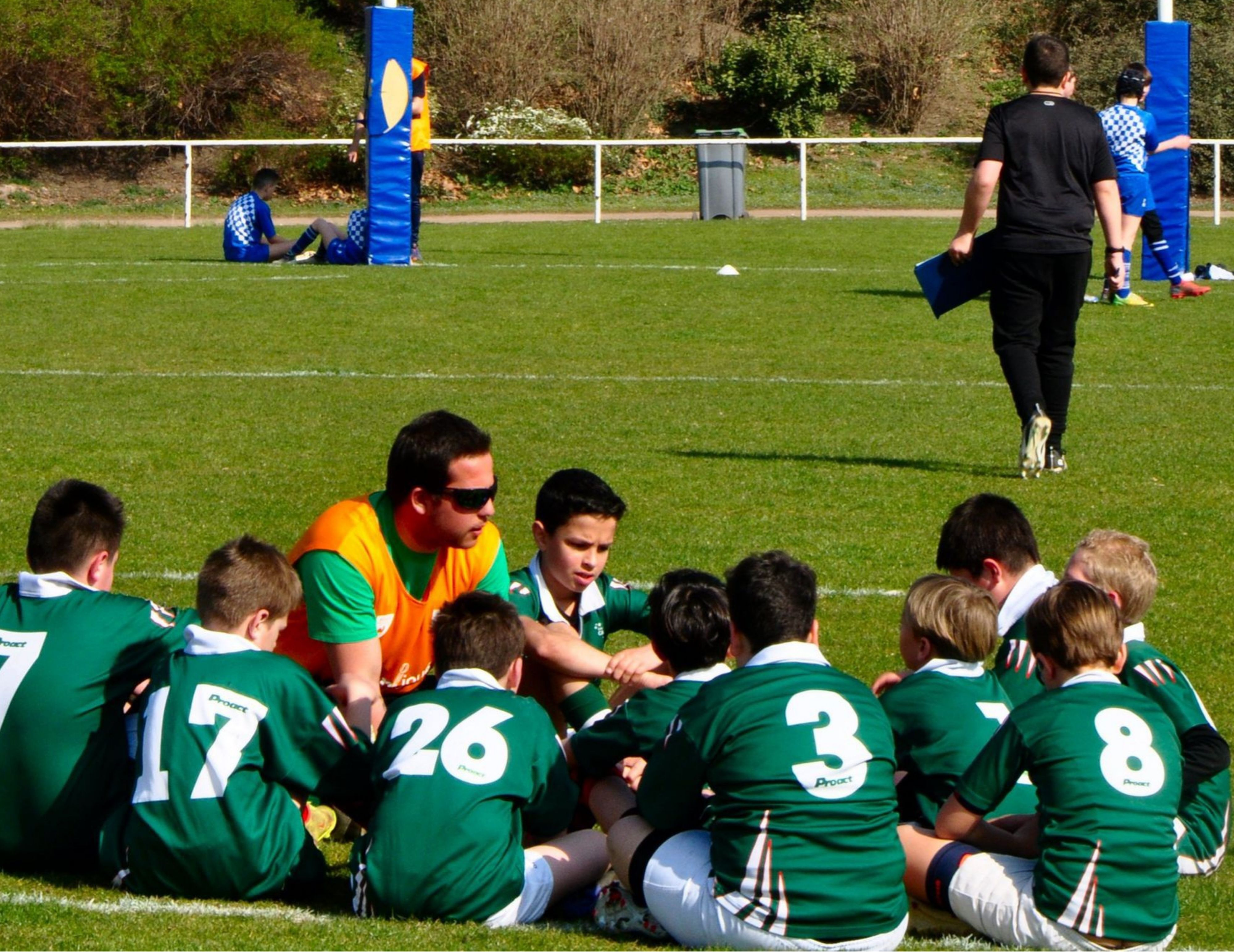 Un coach sportif avec les enfants du club de rugby de ST-ETIENNE